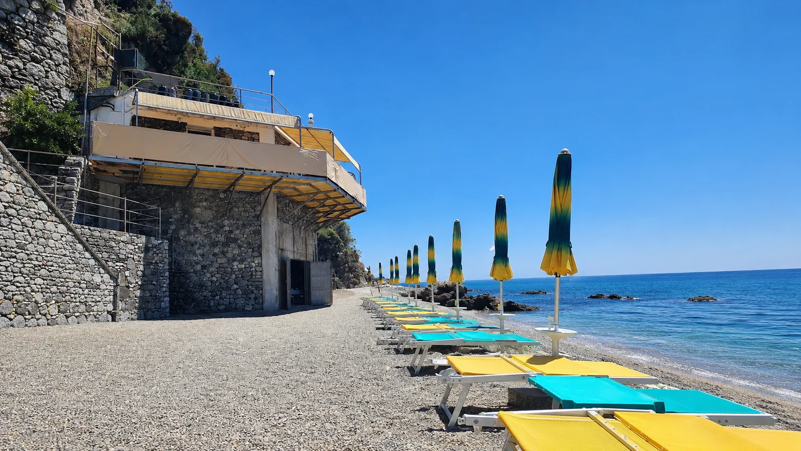 Lettini e ombrelloni OBLO' allineati sulla riva