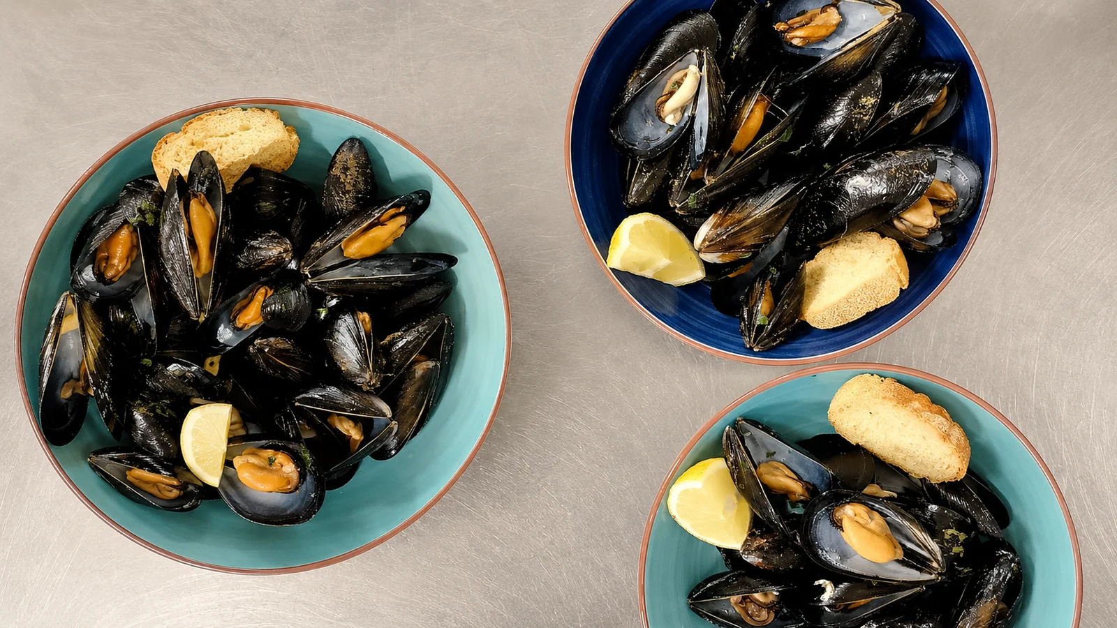 Cozze servite in piatti color mare al ristorante OBLO'