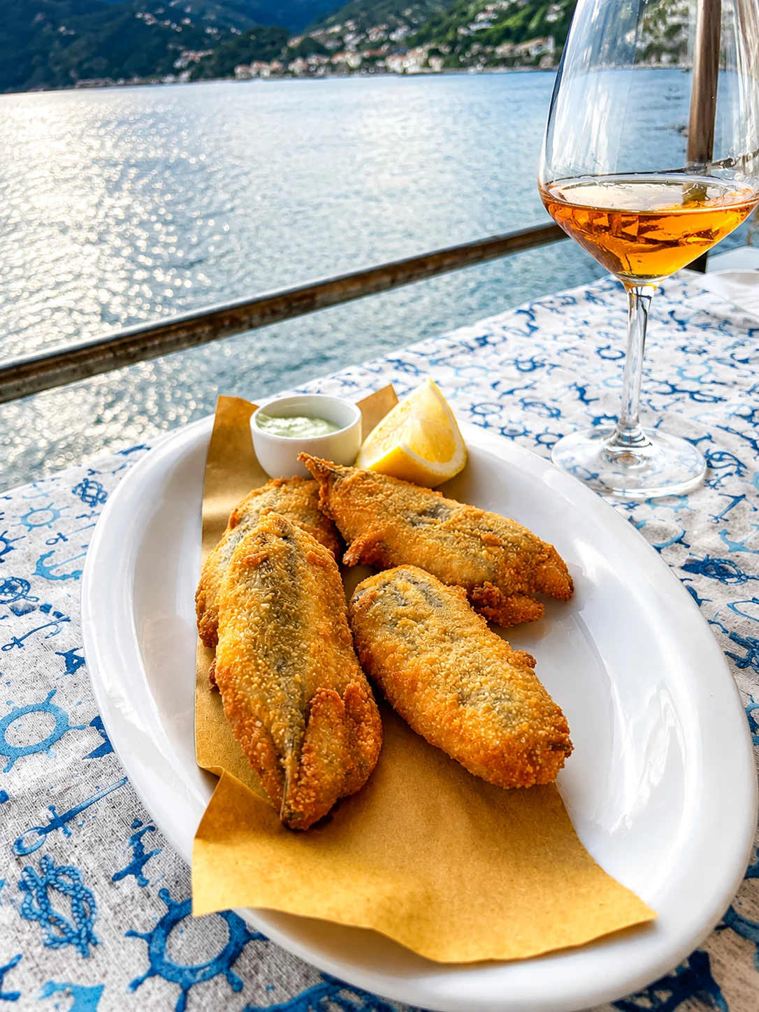 Acciughe ripiene fritte con calice di vino vista mare